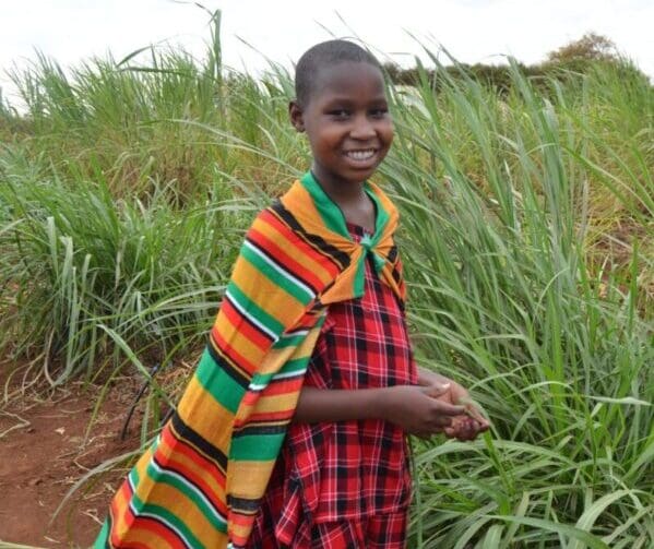 blog stories of empowerment - Young Maasai girl wearing a traditional shuka at MGRC ecoFarm