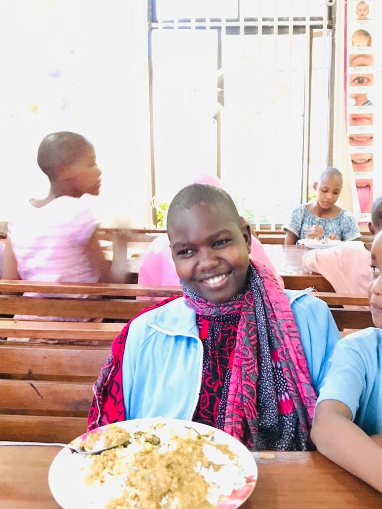 Neema smiling at the lunch table