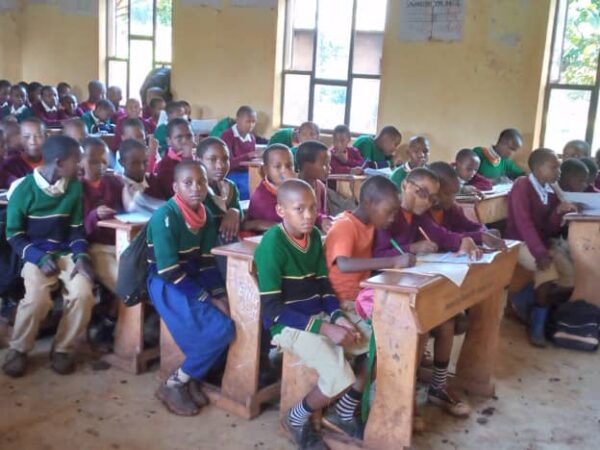 MGRC girls and their classmates sitting at their desks in a classroom