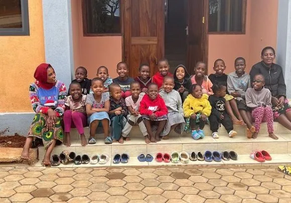 Rescued African girls sitting in front of their new home in Tanzania