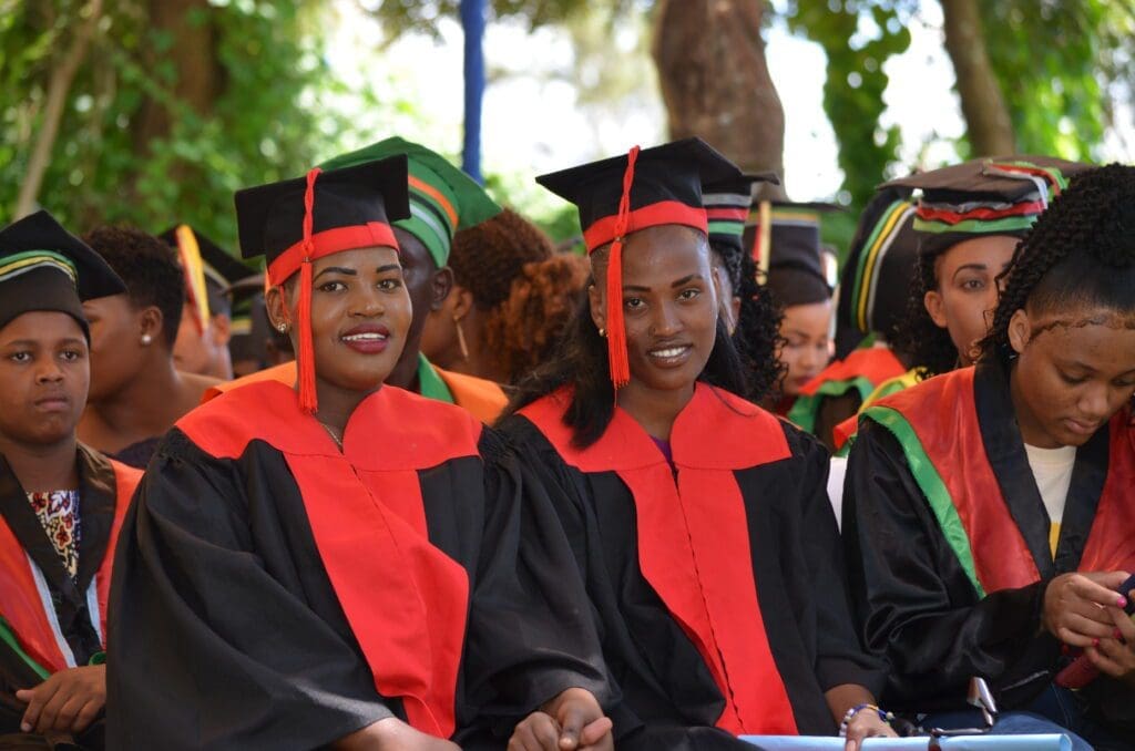 MGRC's first graduates smiling in their cap and gowns. the women empowering Maasai education. 