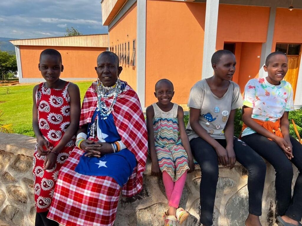 Three MGRC girls sitting with their relatives during our annual community celebration.