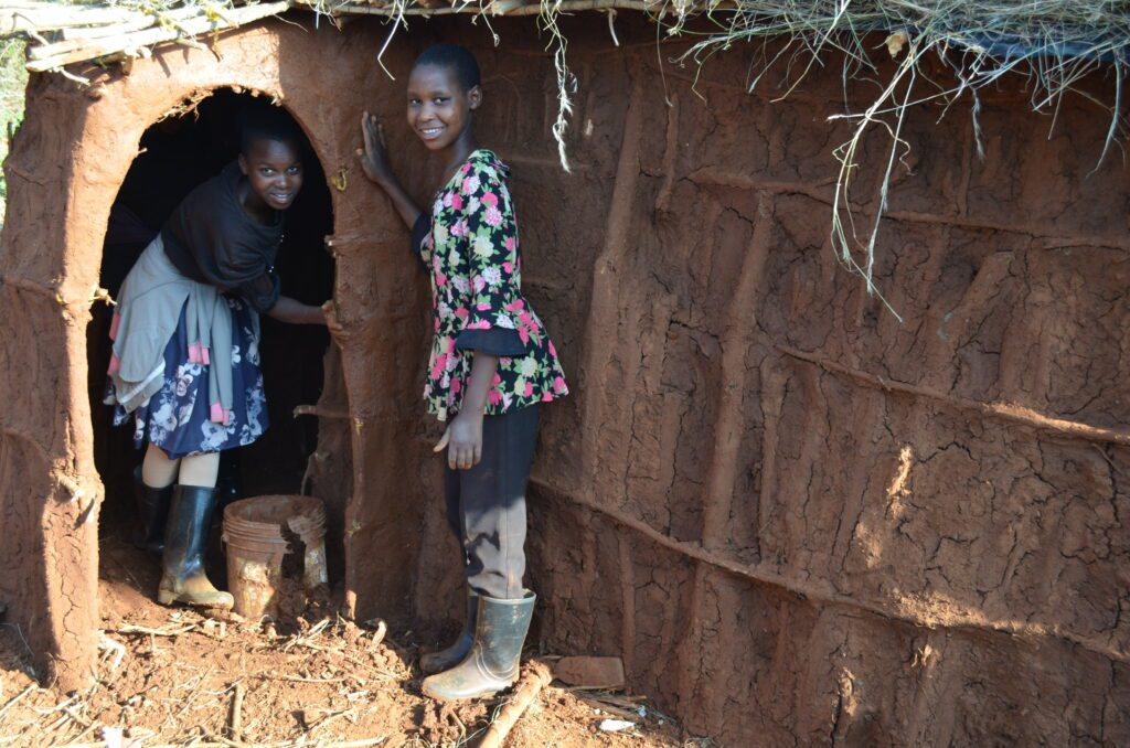Sipapei (left) and Namayani working on the doorway of one of the bomas. 