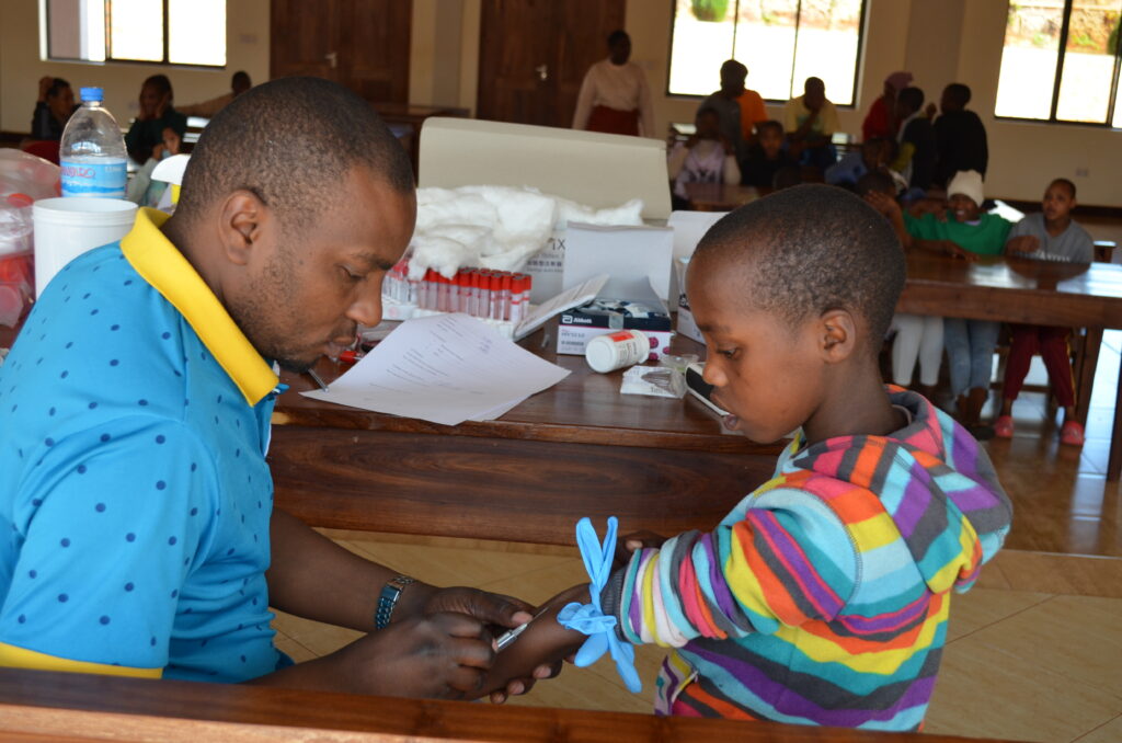 One of our house mothers grimacing whille receiving her immunization shots given by the medical doctor