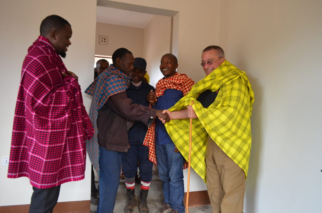 rick and a school official shake hands after the completion of the new classroom project