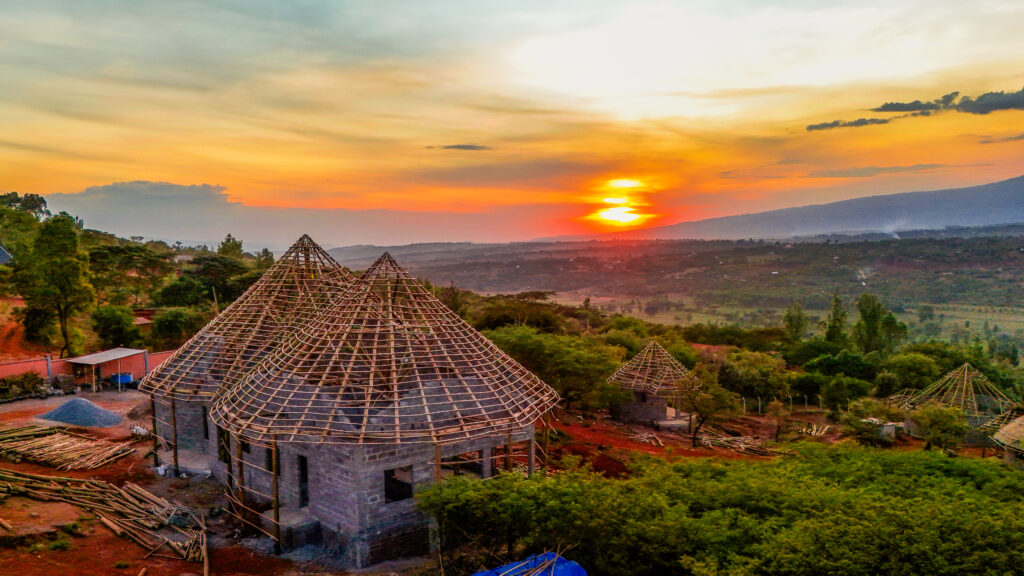 construction progress of the ecolodge with the sunsetting over the valley