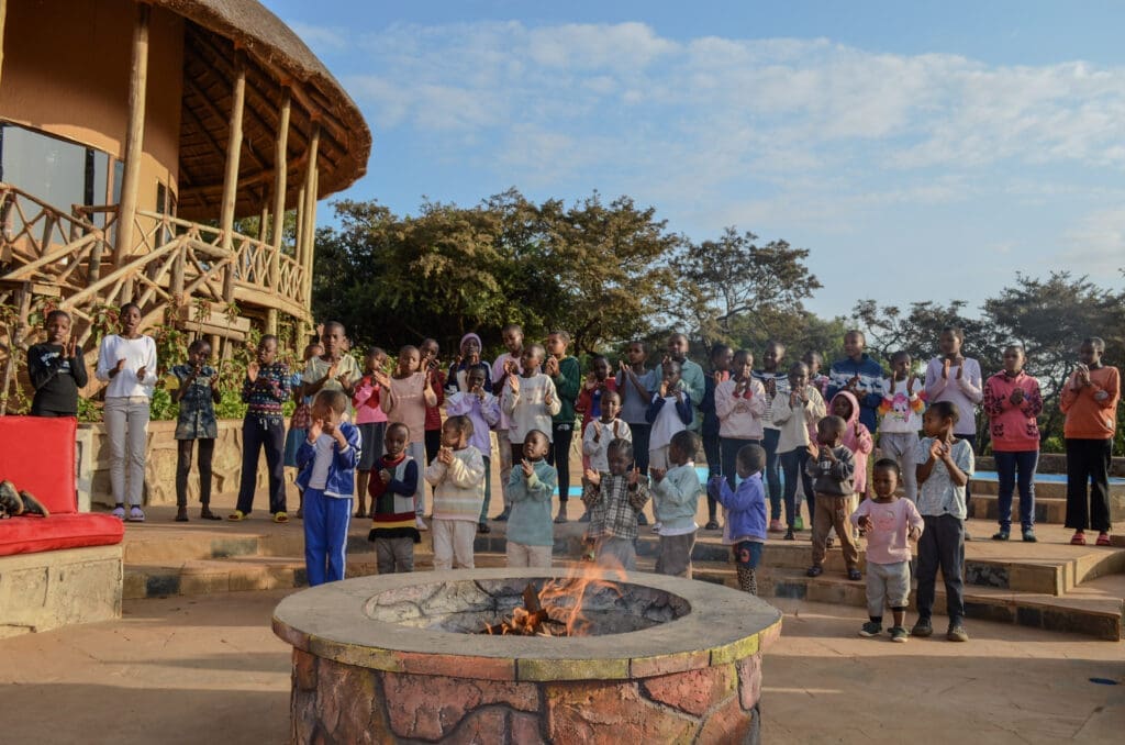 Maasai girls gathered in front of a fire pit at ecoLodge