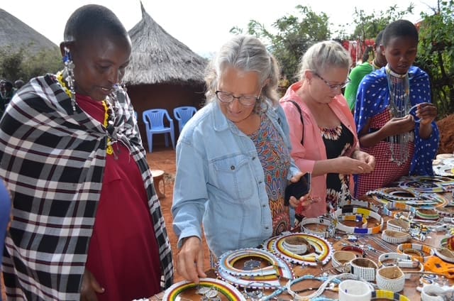 visitors looking at the maasai beadwork displayed at the ecovillage